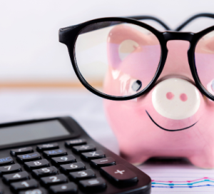 piggy bank wearing glasses with a calculator